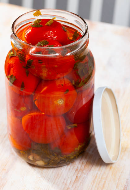 istock Tomatoes marinated in jars on a wooden table 1202290267