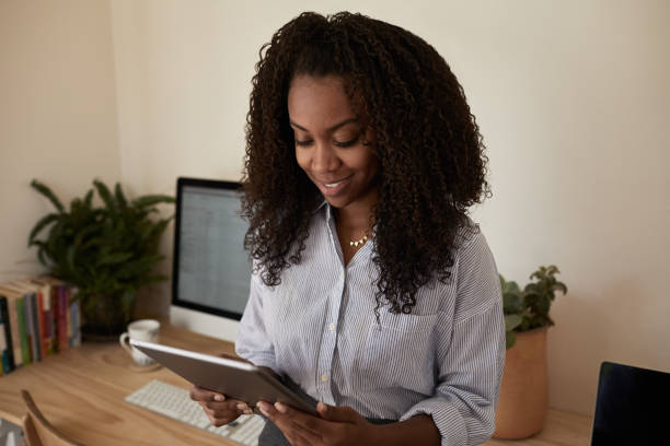istock Young businesswoman smiling and using a tablet in her office 1202292221