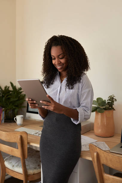 istock Smiling businesswoman using a tablet in her home office 1202292417