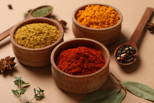 istock Spoons and bowls with different powder spices on craft background, close up 1202292612