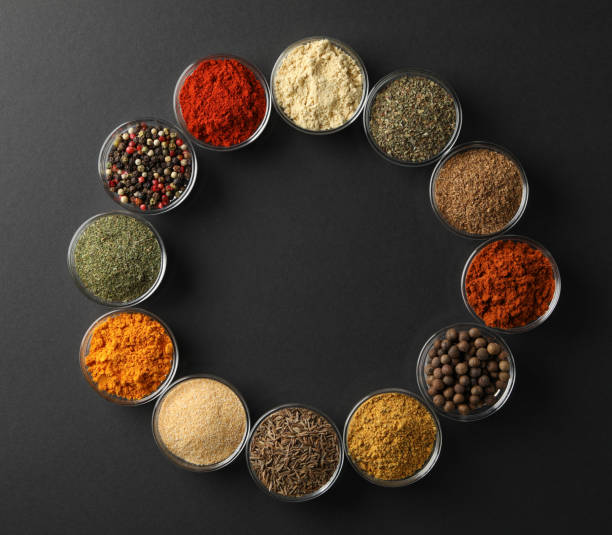 istock Flat lay with bowls of spices on black background, space for text 1202293414