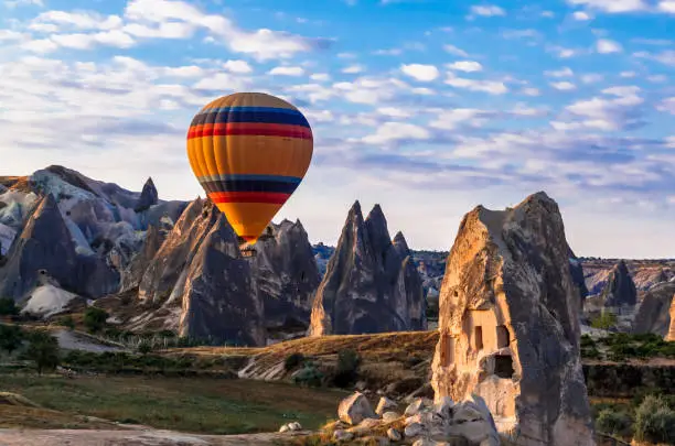Colorful hot air balloons flying over the valley at Cappadocia, Anatolia, Turkey. Volcanic mountains in Goreme national park.