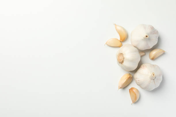 istock Fresh garlic bulbs, slices on white background, top view. Space for text 1202294919