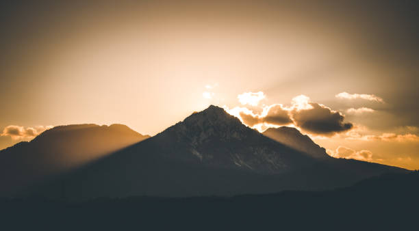 istock Sunset on a mountain, light beams 1202295319