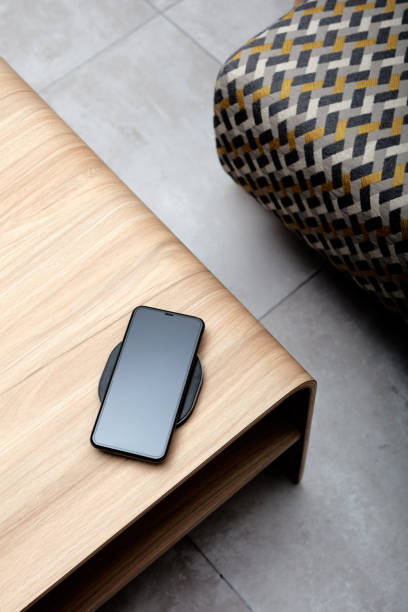 istock A mobile phone charging wirelessly is on a wooden table 1202295498