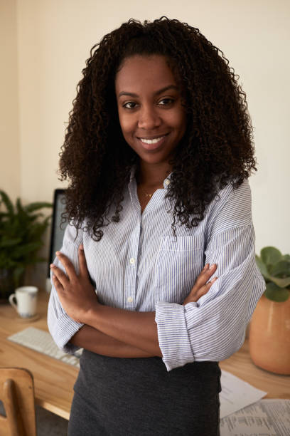 istock Young businesswoman smiling while standing in her home office 1202296770
