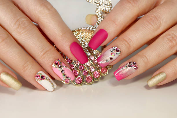 arte de uñas con varias piedras de imitación en forma - uñas de color rosa mate fotografías e imágenes de stock