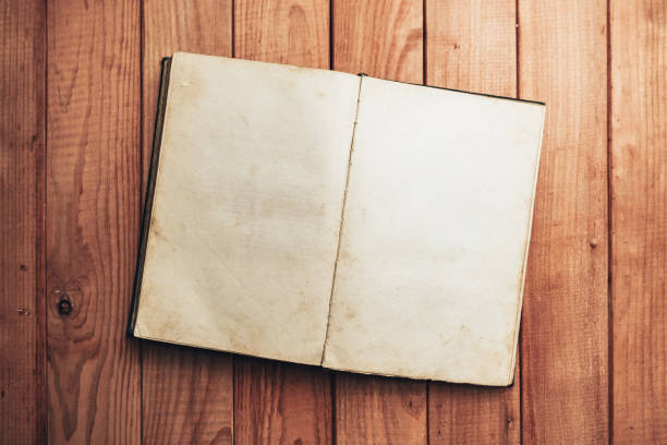 Open Vintage book on a red wooden table background. Top view.