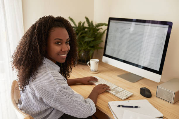 istock Smiling young entrepreneur working on a computer in her home office 1202298058