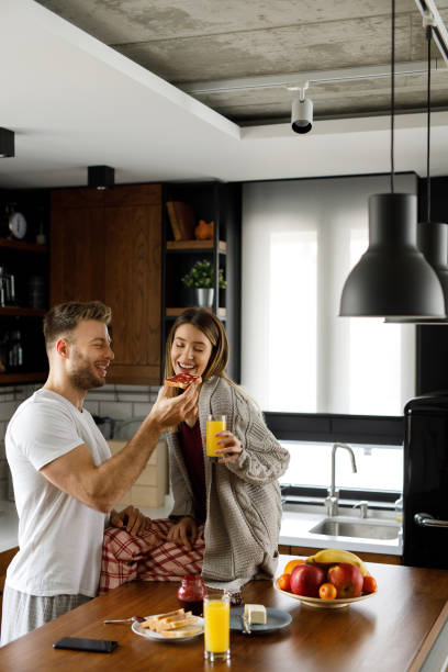 istock Young happy couple eating breakfast in the kitchen 1202299606