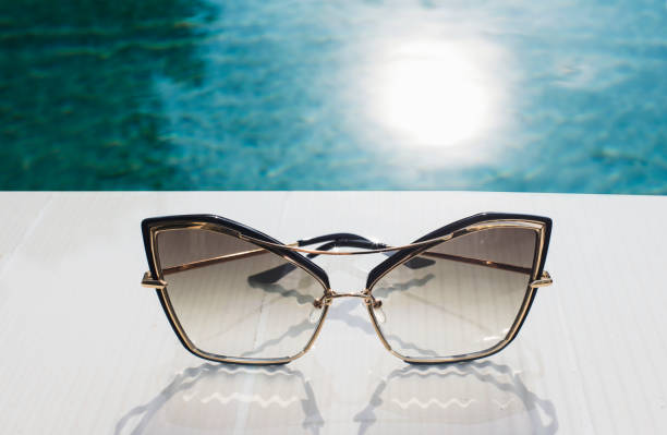 istock Design sunglasses on swimming pool edge 1202299736