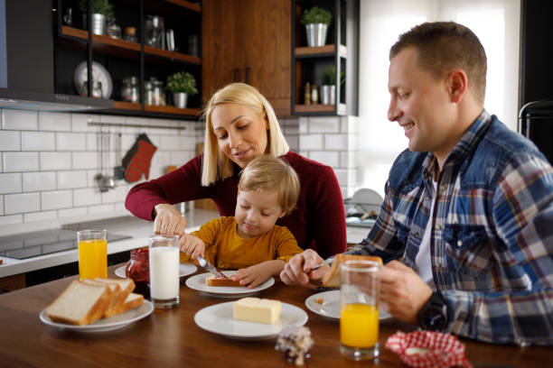 istock Young happy family having breakfast at home 1202300232