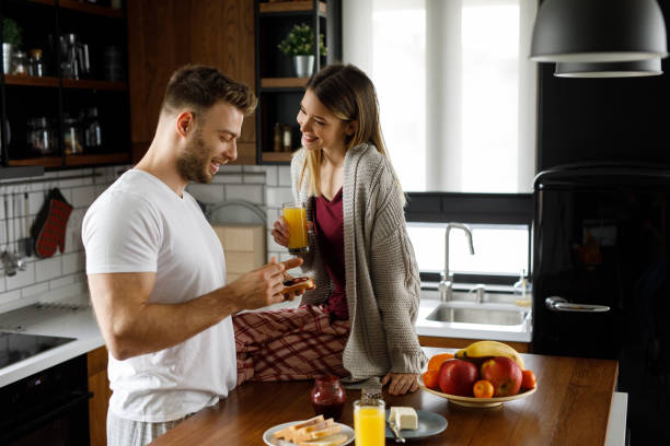 istock Young happy couple eating breakfast in the kitchen 1202300808