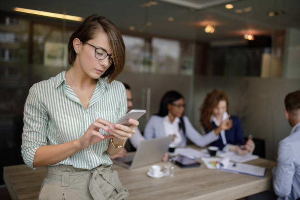 istock Young businesswoman using mobile in the office and text messaging 1202301713