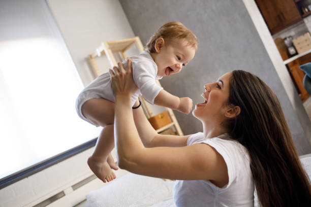 istock Mother playing with her baby boy on bed 1202301824