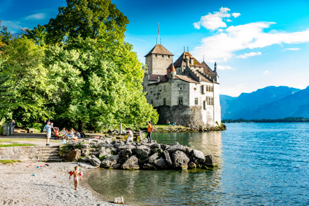 Chateau de Chillon on Lake Geneva, Switzerland Tourists beside Chateau de Chillon on Lake Geneva, Switzerland.  In the background is Lake Geneva and the Swiss Alps. chateau de chillon photos stock pictures, royalty-free photos & images