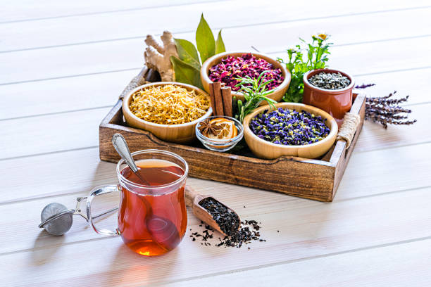 istock Herbal tea cup with various multi colored dried tea leaves and flowers shot on white table 1202307068