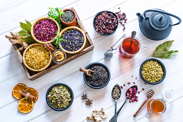 白いテーブルの上に撮影された多色の乾燥茶葉と花の多種多様 - herbal tea ストックフォトと画像