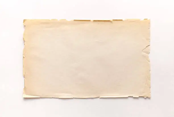 Photo of Old rough recycled paper with ragged edges on a white background with a shadow.