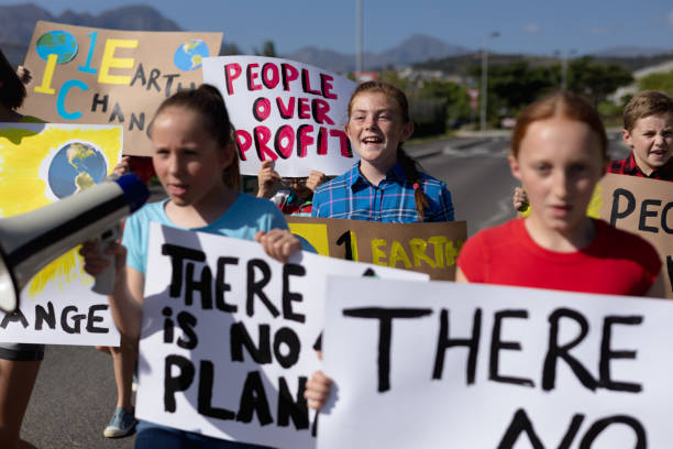istock Group of elementary school pupils walking on a protest march 1202308451