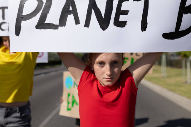 istock Group of elementary school pupils walking on a protest march 1202308530