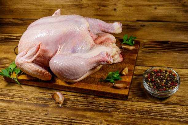 istock Raw whole chicken with spices on a wooden table 1202308674