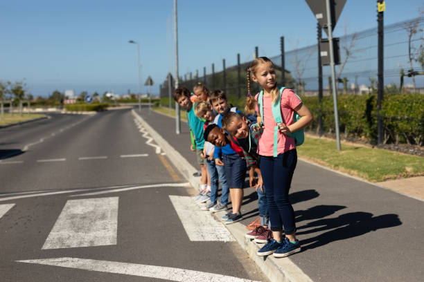 Schoolchildren looking for traffic while waiting to cross the road
