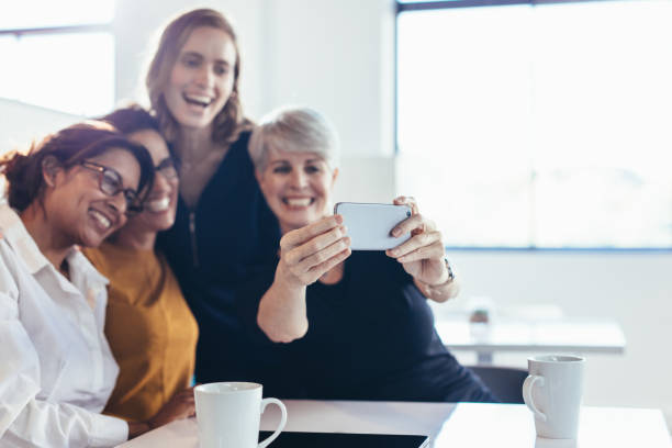 istock Smiling businesswomen making a selfie in office 1202309912