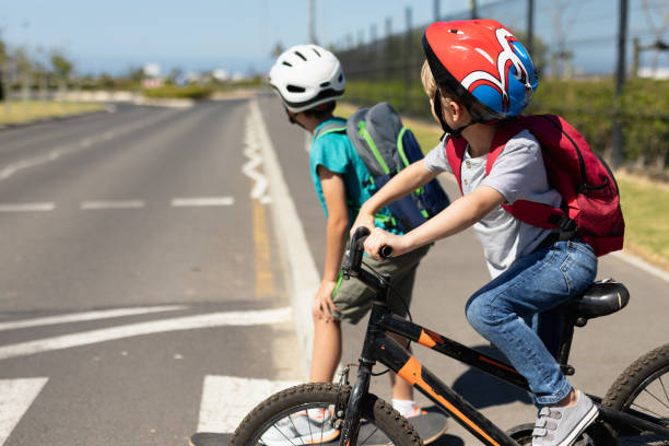 istock Schoolboys looking for traffic while waiting to cross the road 1202310257