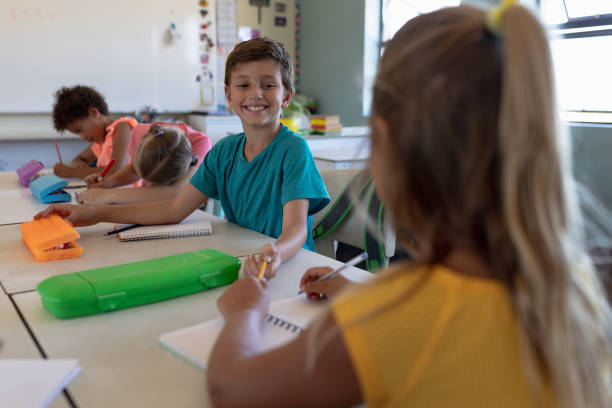 istock Schoolboy sitting at a desk in an elementary school classroom 1202312358