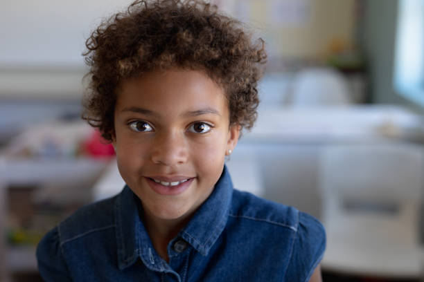 istock Schoolgirl looking to camera in an elementary school classroom 1202312405