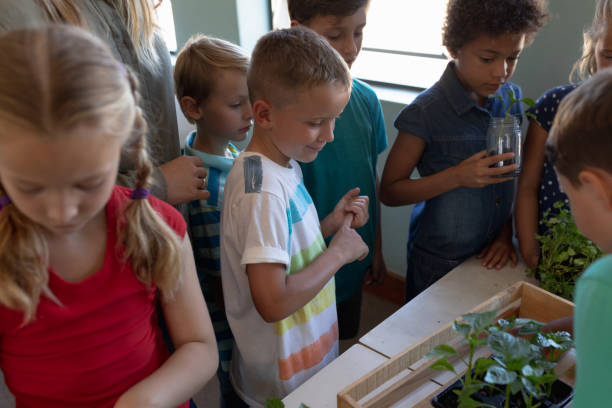 istock Group of schoolchildren looking at plants in an elementary school classroom 1202313861