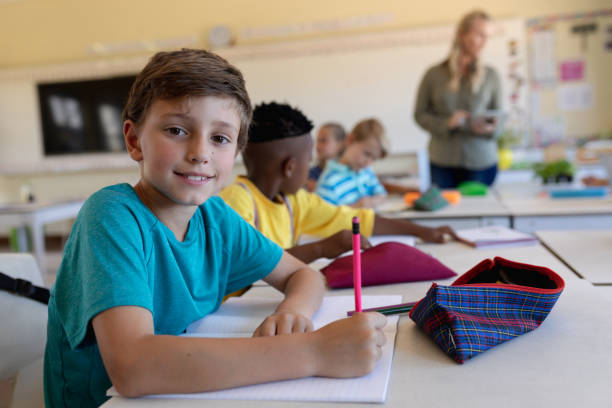 istock Schoolboy sitting at a desk in an elementary school classroom 1202313992