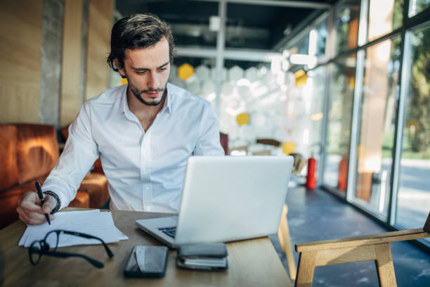 istock Businessman working on laptop in cafe 1202314308