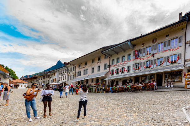 Beautiful view of the medieval town of Gruyeres, home to the world-famous Le Gruyere cheese, canton of Fribourg, Switzerland. There are tourists in the main street.
