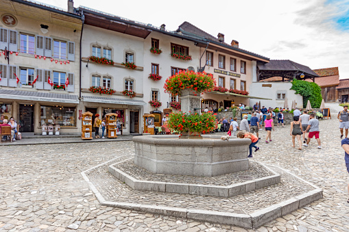 Beautiful view of the medieval town of Gruyeres, home to the world-famous Le Gruyere cheese, canton of Fribourg, Switzerland. There are tourists in the main street.