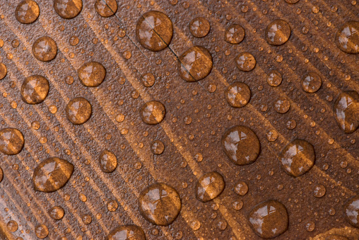 Raindrops on a varnished wooden surface.