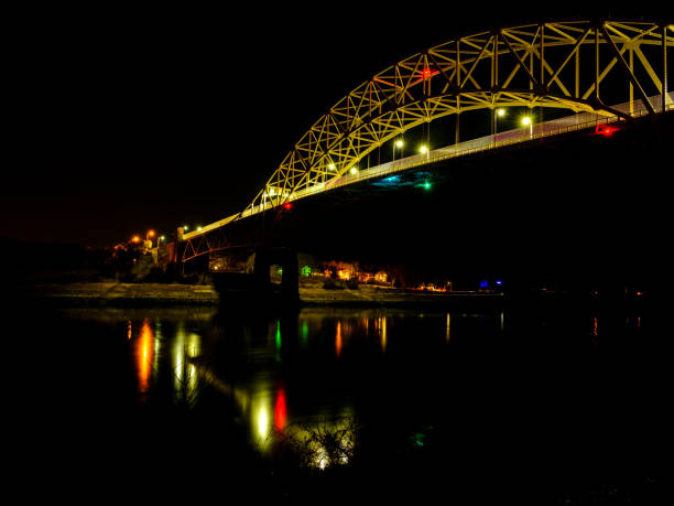 istock Golden Colored Sagamore Bridge and Colorful Light Reflections on Cape Cod Canal, Night Photography 1202315309