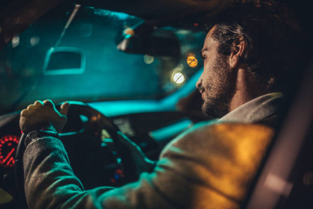istock Businessman Driving A Car In Night 1202315316