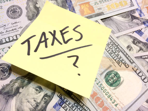 American cash money and yellow post it note with text Taxes with question mark American cash money and yellow post it note with text Taxes with question mark in black color aerial view philadelphia federal reserve stock pictures, royalty-free photos & images