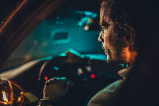 istock Businessman Driving A Car In Night 1202315448