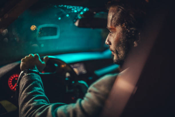 istock Businessman Driving A Car In Night 1202315523