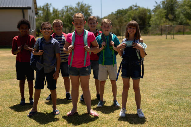 istock Group of schoolchildren standing in a playing field at elementary school 1202315720