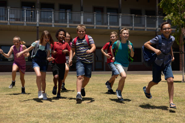 istock Group of schoolchildren running in a playing at elementary school 1202315739