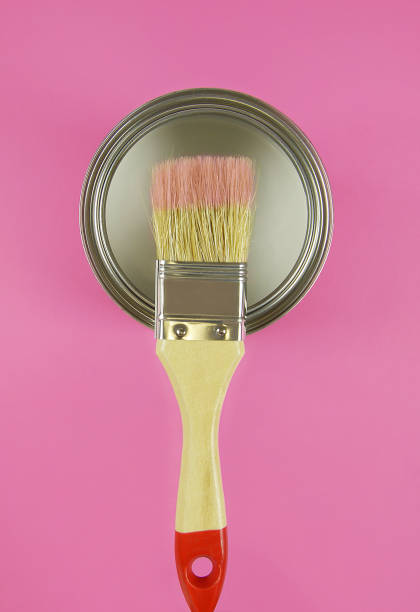 istock Paint can and brush on a pink background 1202316922