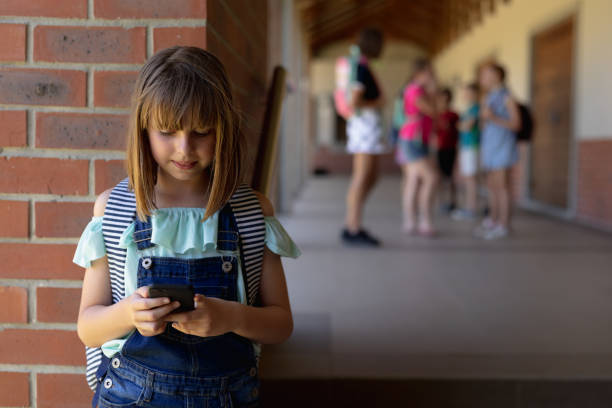 istock Schoolgirl leaning against a wall in the schoolyard at elementary school 1202317565