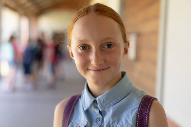 istock Schoolgirl standing in the schoolyard at elementary school 1202317631