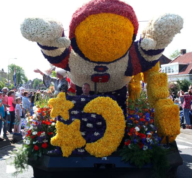 Bloemencorso (Blossom Course) bulb flower parade. Lisse, Netherlands: Carnival floats showing years bulb flower harvest. Astronaut float passes through Sassenheim.
