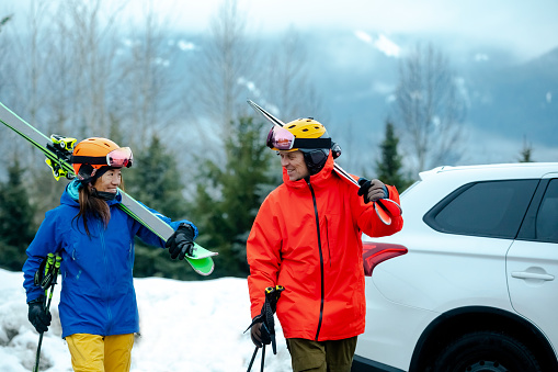 Mixed race couple going skiing. Adult ski vacations. Active lifestyle with a car.