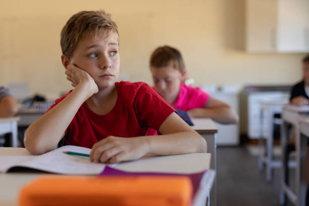 istock Schoolboy sitting at a desk in an elementary school classroom 1202319959